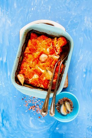 Flat-lay of baked salmon fish on blue background top viewの写真素材
