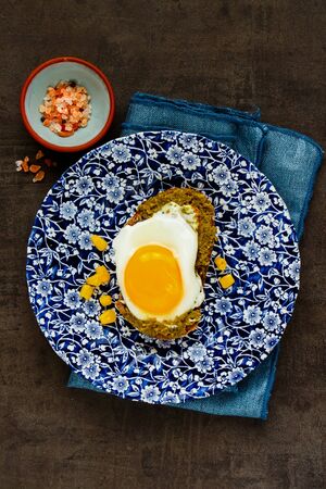 Flat-lay of fried egg sandwich with pesto sauce and sweet corn on vintage tableの写真素材