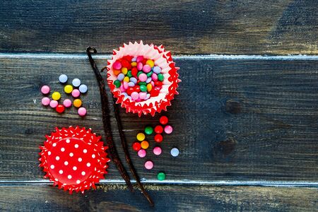 Flat-lay of baking birthday cupcakes ingredients over dark wood backgroundの写真素材