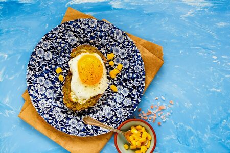 Tasty fried egg sandwich with pesto sauce on blue background flat layの写真素材
