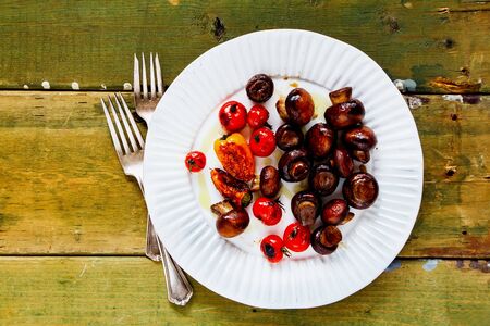 Grilled vegetables with baked mushrooms on wooden background flat layの写真素材