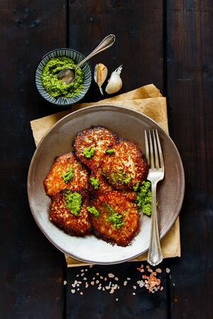 Flat-lay of potato pancakes with pesto sauce on vintage wooden table の写真素材