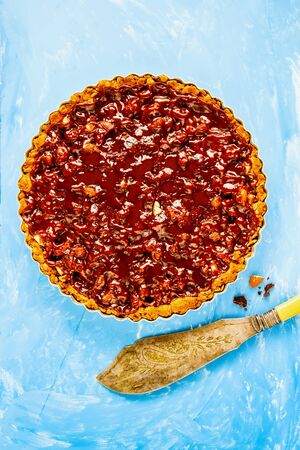 Caramel chocolate and almond tart on blue backgroundの写真素材