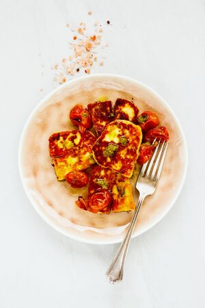 Roasted cheese and tomatoes on white background flat layの写真素材