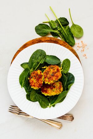 Healthy vegetable pancakes and fresh spinach on plate flat layの写真素材