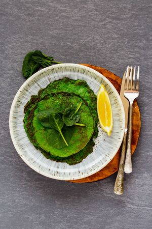 Healthy green spinach pancakes in plate on grey background flat layの写真素材