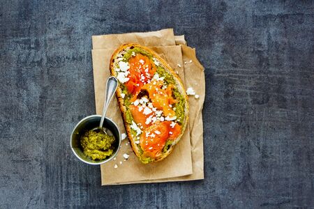 Toast with smoked salmon, pesto and feta on vintage table flat layの写真素材