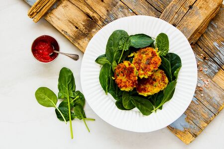 Vegetable pancakes and spinach on plate top viewの写真素材