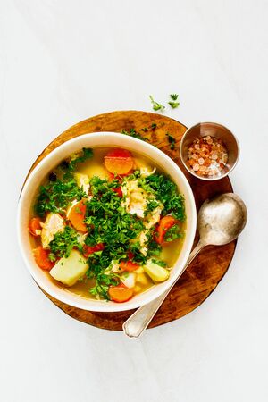 Red fish soup with salmon in bowl on wooden cutting board の写真素材