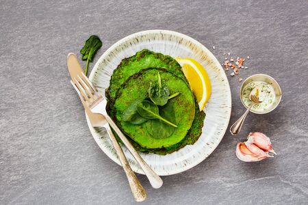 Homemade spinach pancakes and yogurt dressing with fresh herbs の写真素材