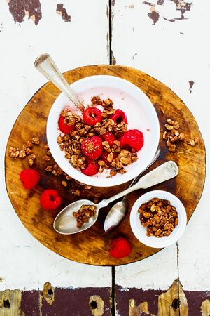 Yogurt dessert with chocolate granola and fresh berries on wooden tableの写真素材
