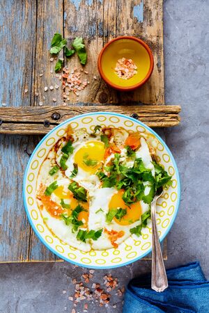 Delicious breakfast with fried eggs and salmon in bowl flat layの写真素材