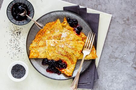 Homemade poppyseed pancakes with wild blueberry jam on light backgroundの写真素材