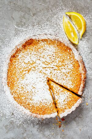 Sliced Lemon tart sprinkled with icing sugar on light backgroundの写真素材