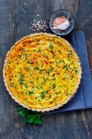 Tasty classic cheese quiche with fresh herbs flat layの写真素材