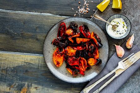 Oven-baked sweet peppers with yogurt dressing in plate top viewの写真素材