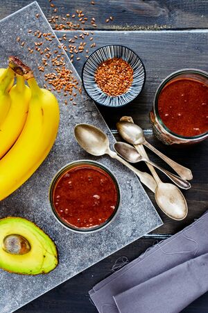 Avocado, chocolate, banana smoothie in jars on dark backgroundの写真素材