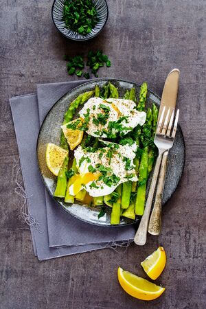 Flat-lay of plate with aspargus and poached eggs on vintage board の写真素材