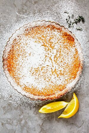 Lemon tart sprinkled with icing sugar on light background top viewの写真素材