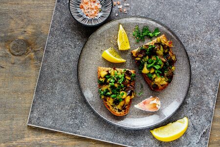 Fresh oven-roasted warm aubergine salad on bread flat-layの写真素材