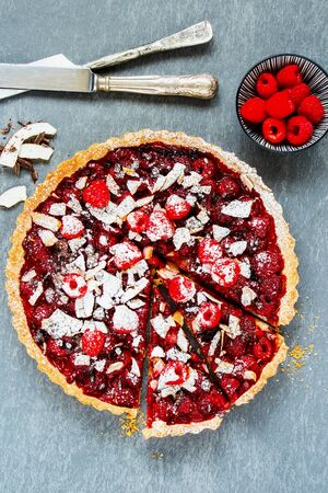 Sliced raspberry chocolate tart on light background flat layの写真素材
