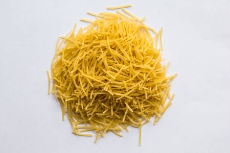 Dry pasta heap on white backgroundの写真素材