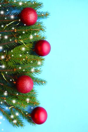Christmas tree branches with red balls on blue background. Banner, verticalの写真素材