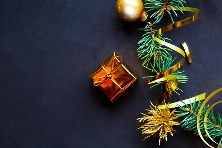 Flat lay photo with Christmas tree branches and golden decorations on black background. Top view, copy space, bannerの写真素材