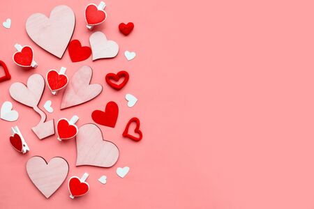 Wooden hearts on pastel pink background. Flat lay, top view, copy space. Valentine's Day greeting cardの写真素材