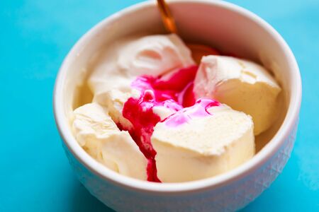 Ice cream in white bowl with cherry syrupの写真素材