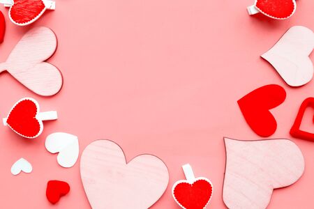 Wooden hearts on pastel pink background. Flat lay, top view, copy space. Valentine's Day greeting cardの写真素材