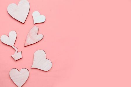 Wooden hearts on pastel pink background. Flat lay, top view, copy space. Valentine's Day greeting cardの写真素材