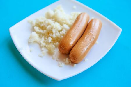 sausages and rice on white plateの写真素材