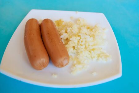sausages and rice on white plateの写真素材