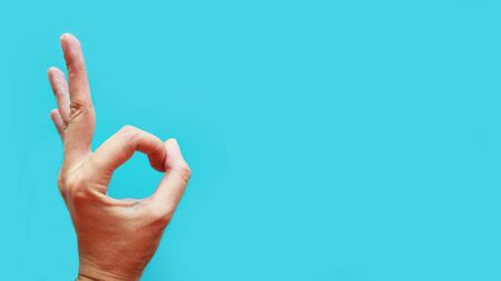 Hand ok sign over blue background, copy spaceの写真素材