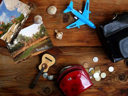 Flat lay photo in retro style - photos, seashells, gutar and camera on wooden background. Travel conceptの写真素材