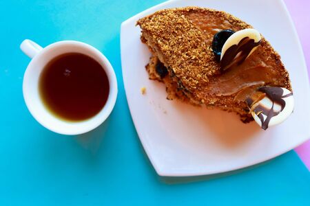 Sliced tasty chocolate cake and tea cup, top viewの写真素材