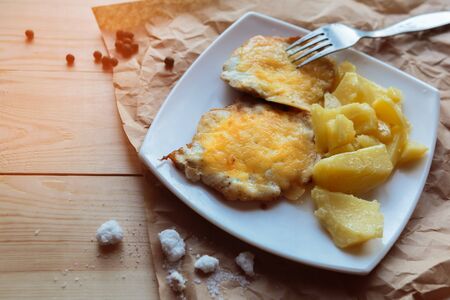 Roasted potato and meat in cheese on white plateの写真素材