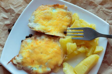 Roasted potato and meat in cheese on white plate. Top ivew, closeupの写真素材