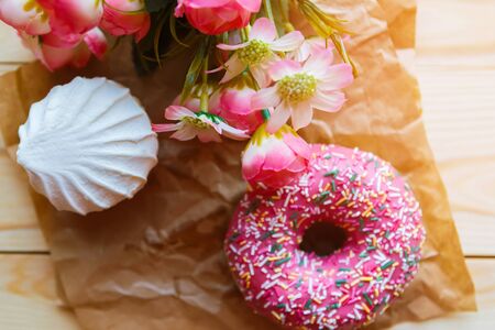 white marshmallow and pink donut on crumpled paper, top viewの写真素材