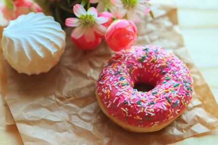 white marshmallow and pink donut on crumpled paperの写真素材