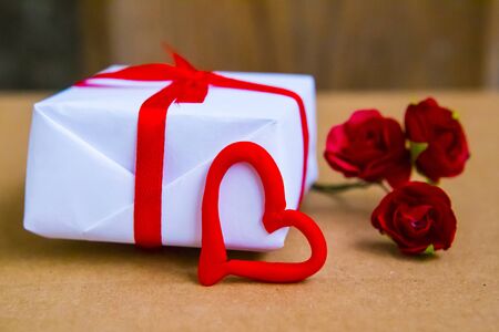 Gift box and flowers on the table. Valentine's Day or wedding greeting cardの写真素材