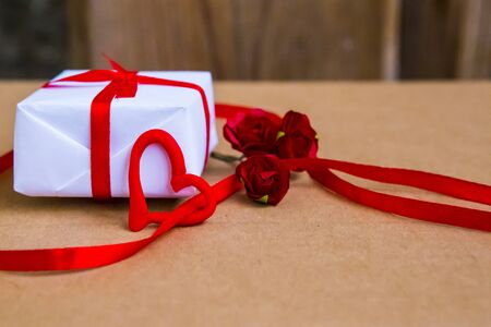 Gift box and flowers on the table. Valentine's Day or wedding greeting cardの写真素材