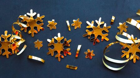 Golden decorations on black background. Flat lay, top view, copy space. Merry Christmas and Happy New Yearの写真素材