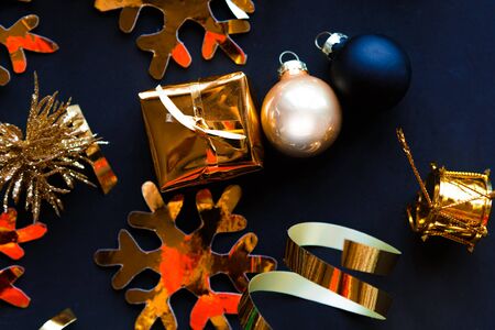 Golden decorations on black background. Flat lay, top view, copy space. Merry Christmas and Happy New Yearの写真素材