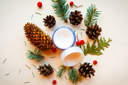 Cream container, cones and spruce branches on white background, top view. Natural cosmetic products conceptの写真素材