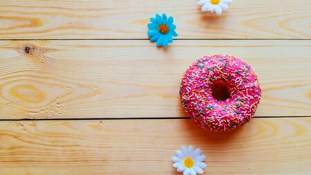 Strawberry donut with colorful sprinkles on wooden background, copy spaceの写真素材