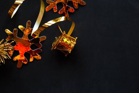 Golden decorations on black background. Flat lay, top view, copy space. Merry Christmas and Happy New Yearの写真素材