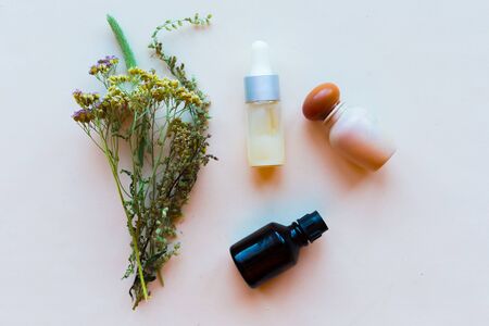 Cosmetic bottles and herbs on white background, top view. Natural cosmetic products conceptの写真素材