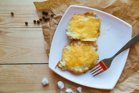 meat in cheese on white plate, top viewの写真素材